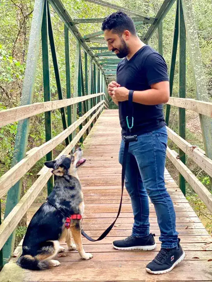 Man holding dog on leash on a bridge during dog training in Austin, TX
